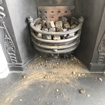 Broken pieces of chimney in the fireplace.